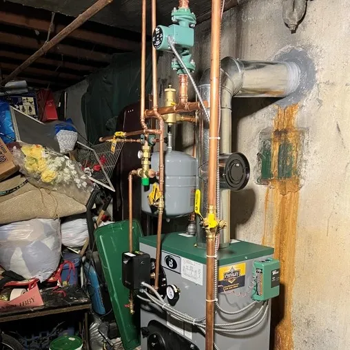 Boiler controls and heating components being checked after loss of heat in Massapequa, NY.