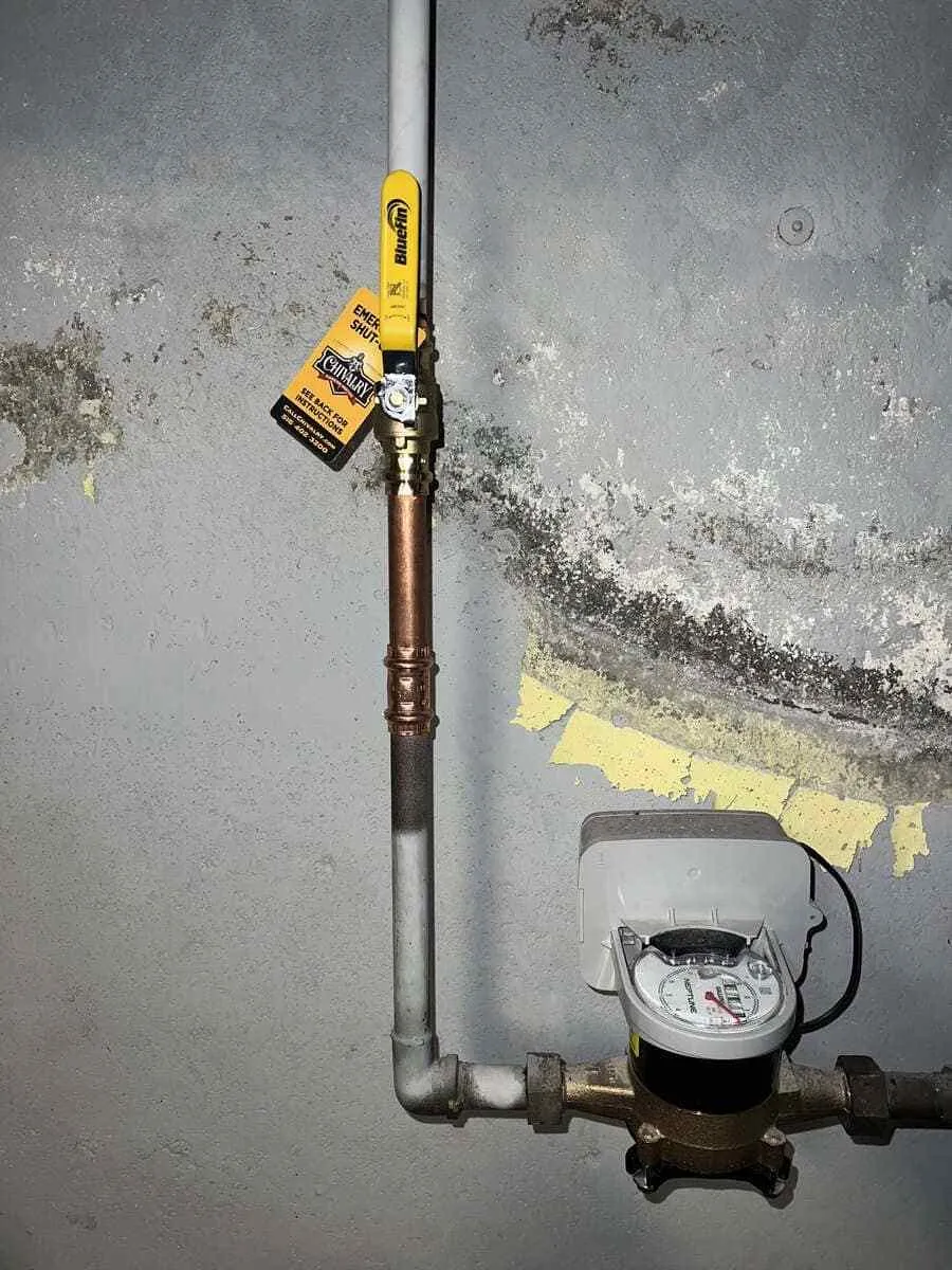 Boiler and nearby heating connections being inspected for signs of a water leak in Wantagh, NY. Boiler repair near me